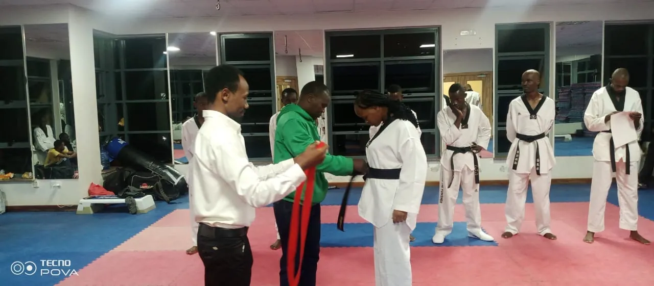 Taekwondo instructor awarding a belt to an athlete