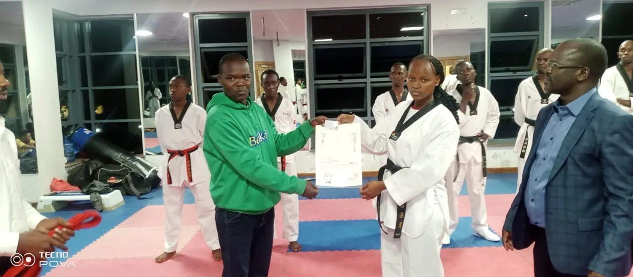 Coach and athlete presenting a taekwondo achievement certificate